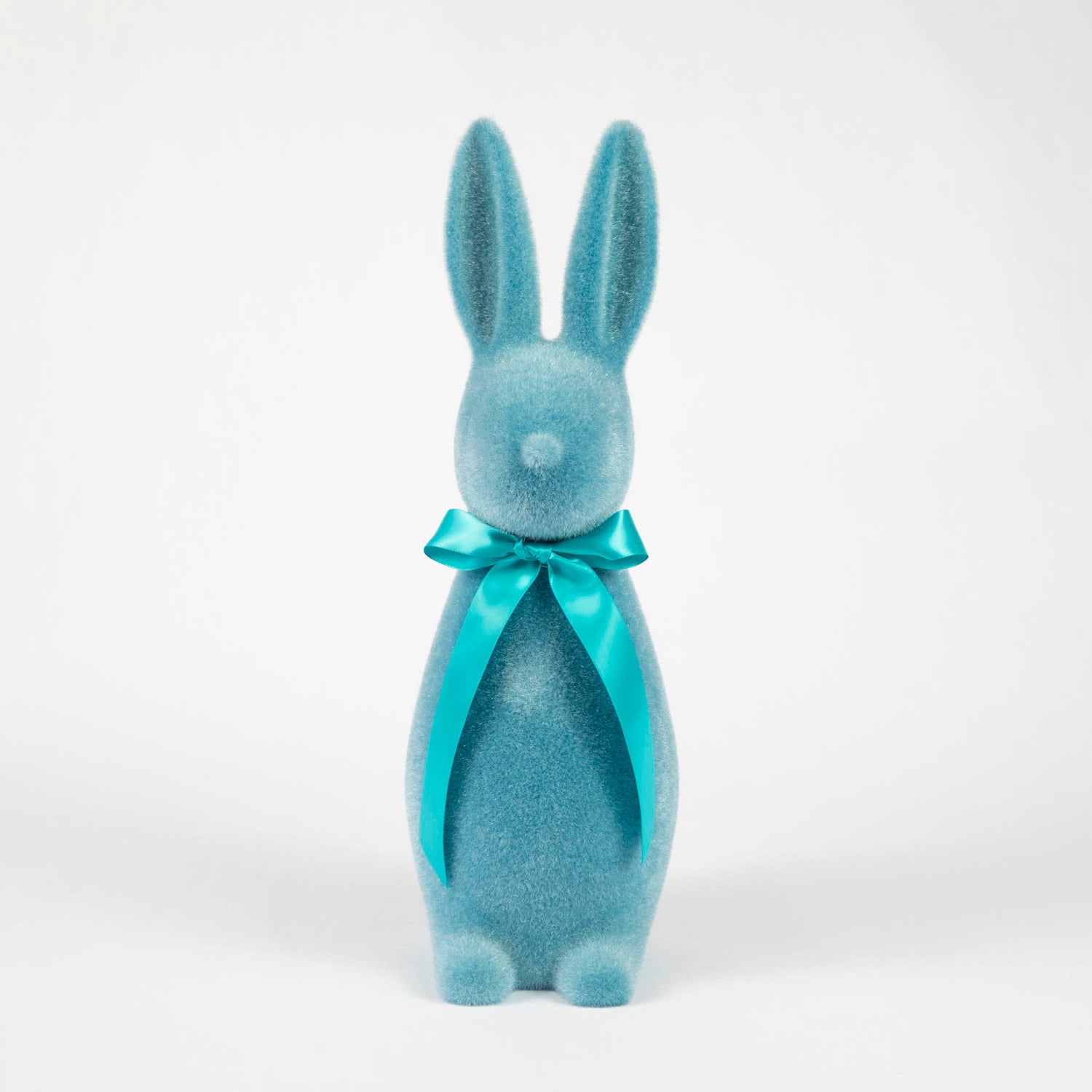 A Glitterville Medium Flocked Button Nose Bunny with soft pastel coloring, wearing a blue bow, perfect for Easter celebration.