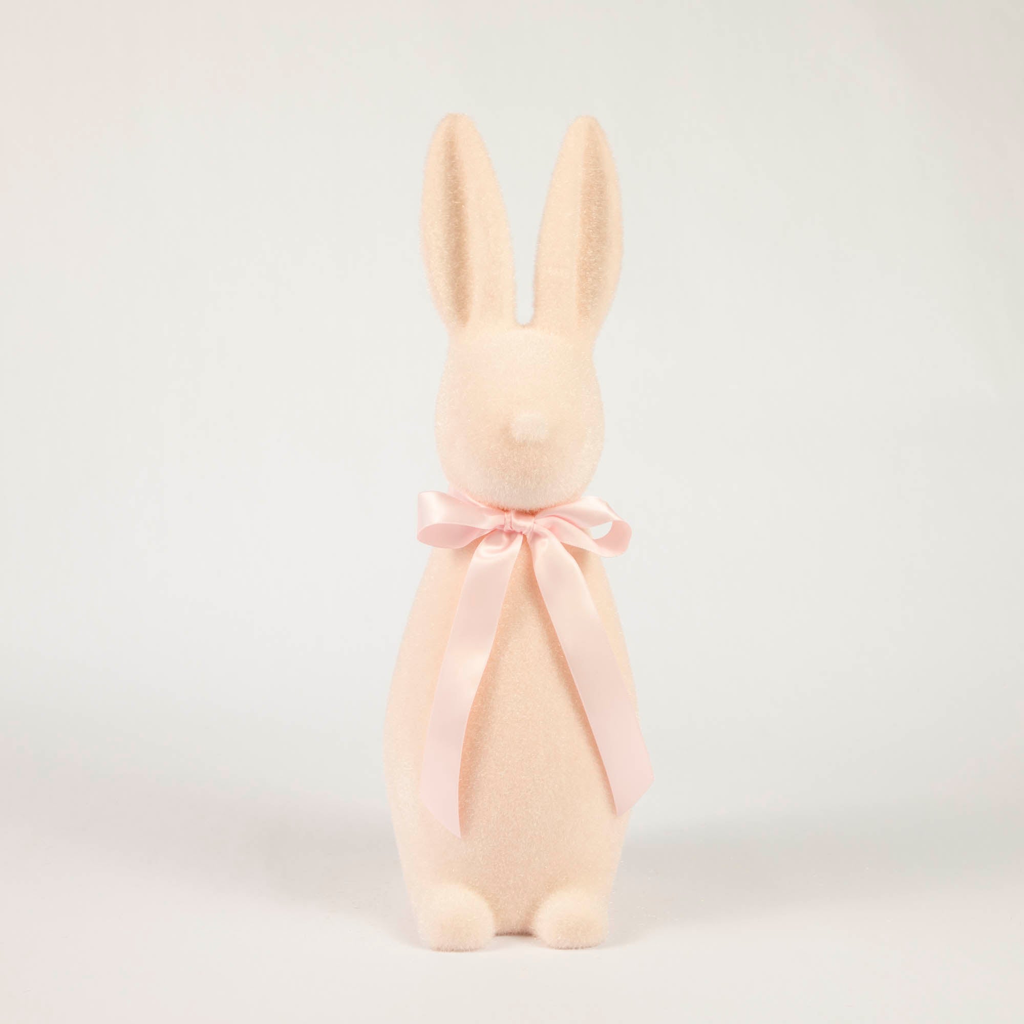 A Medium Flocked Button Nose Bunny from Glitterville with a pink bow on a white background, perfect for Easter celebration.