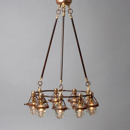Antique bronze chandelier with multiple glass lampshades and antique insulators suspended from the ceiling, made in the USA by Hester &amp; Cook&