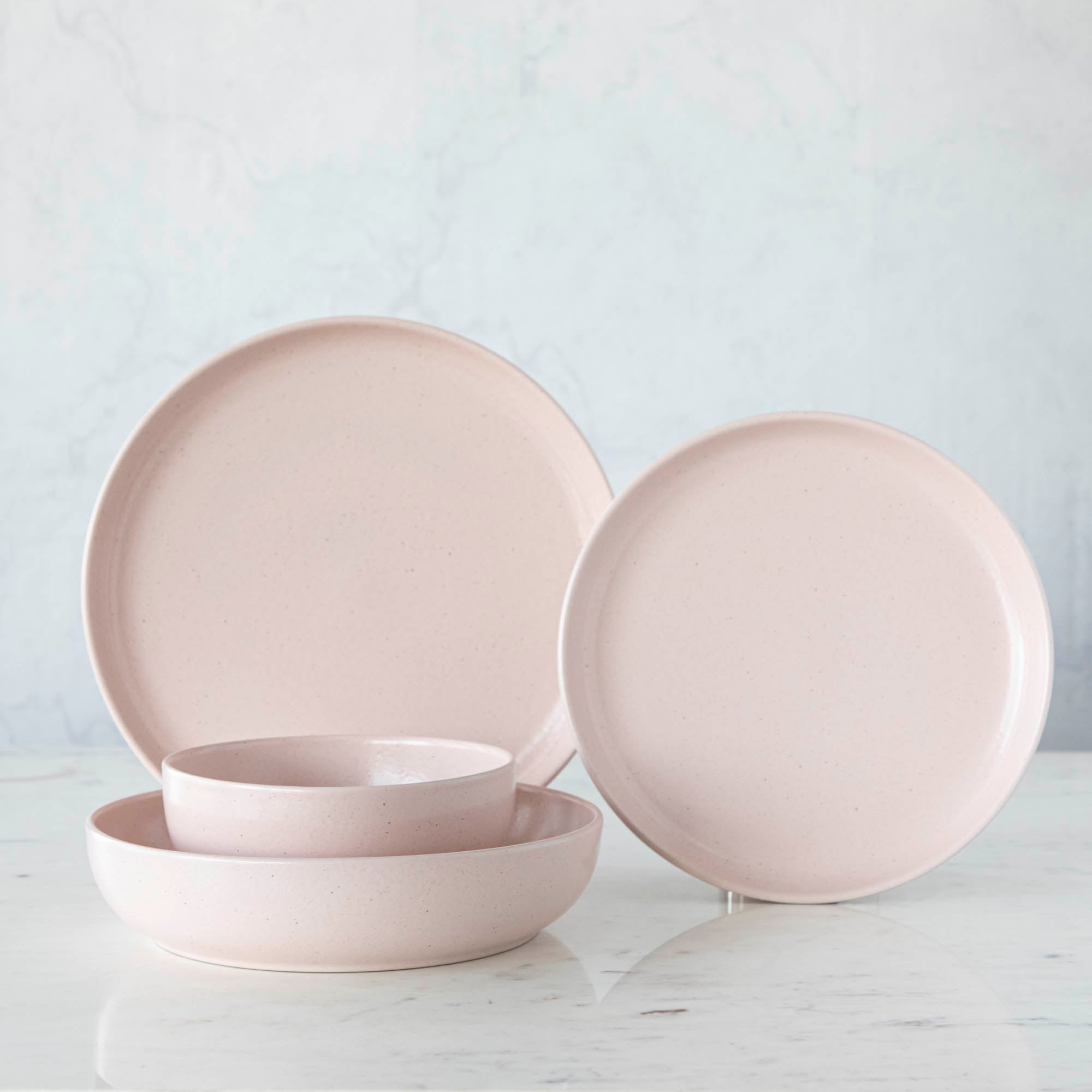 A set of Pacifica Marshmallow Dinnerware plates and bowls from the Casafina Living collection with a matte finish, placed on a table.