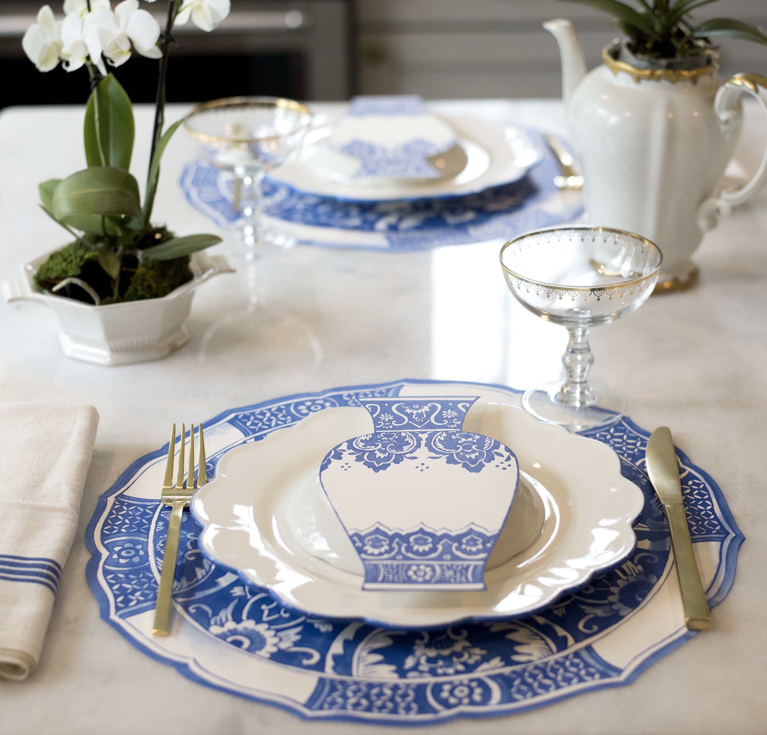An elegant table setting featuring Chine Blue Vase Table Accents resting on each plate.