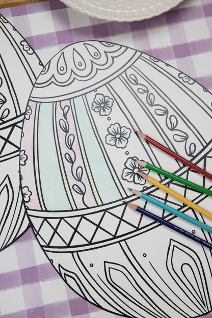 The Die-cut Coloring Easter Egg Placemat on an Easter-themed table setting, partially filled in with colored pencils. 