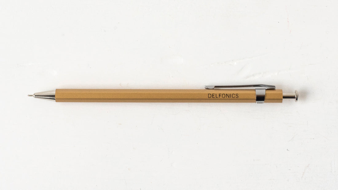 A beige wooden ball pen with the brand name &
