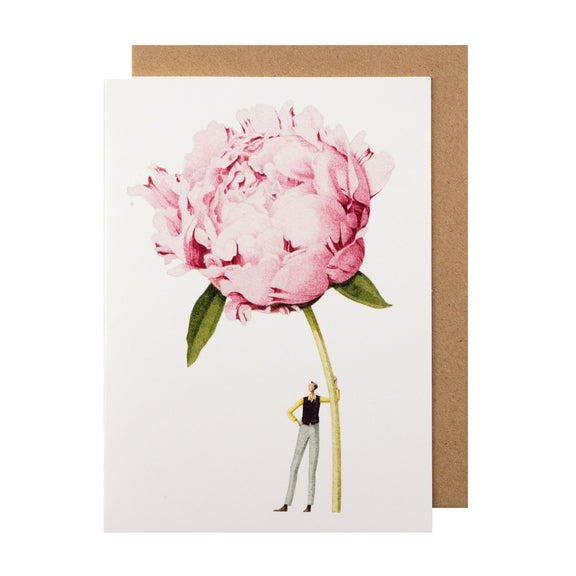 Illustration of a small person standing next to a disproportionately large Pink Peony Greeting Card on Hester &amp; Cook environmentally sustainable paper.