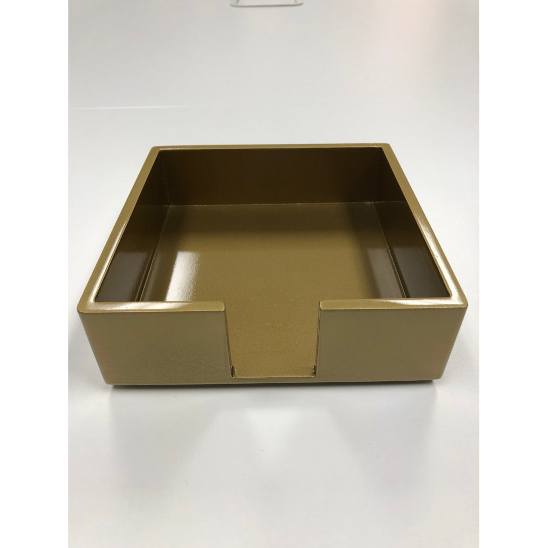 A gold lacquered cocktail napkin holder. 