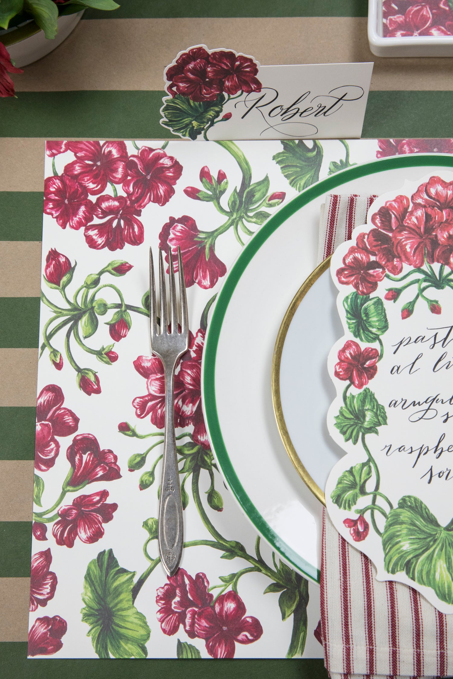 A set of Geranium Garden Placemats with vibrant geraniums, adorned with leaves and vines, from Hester &amp; Cook.