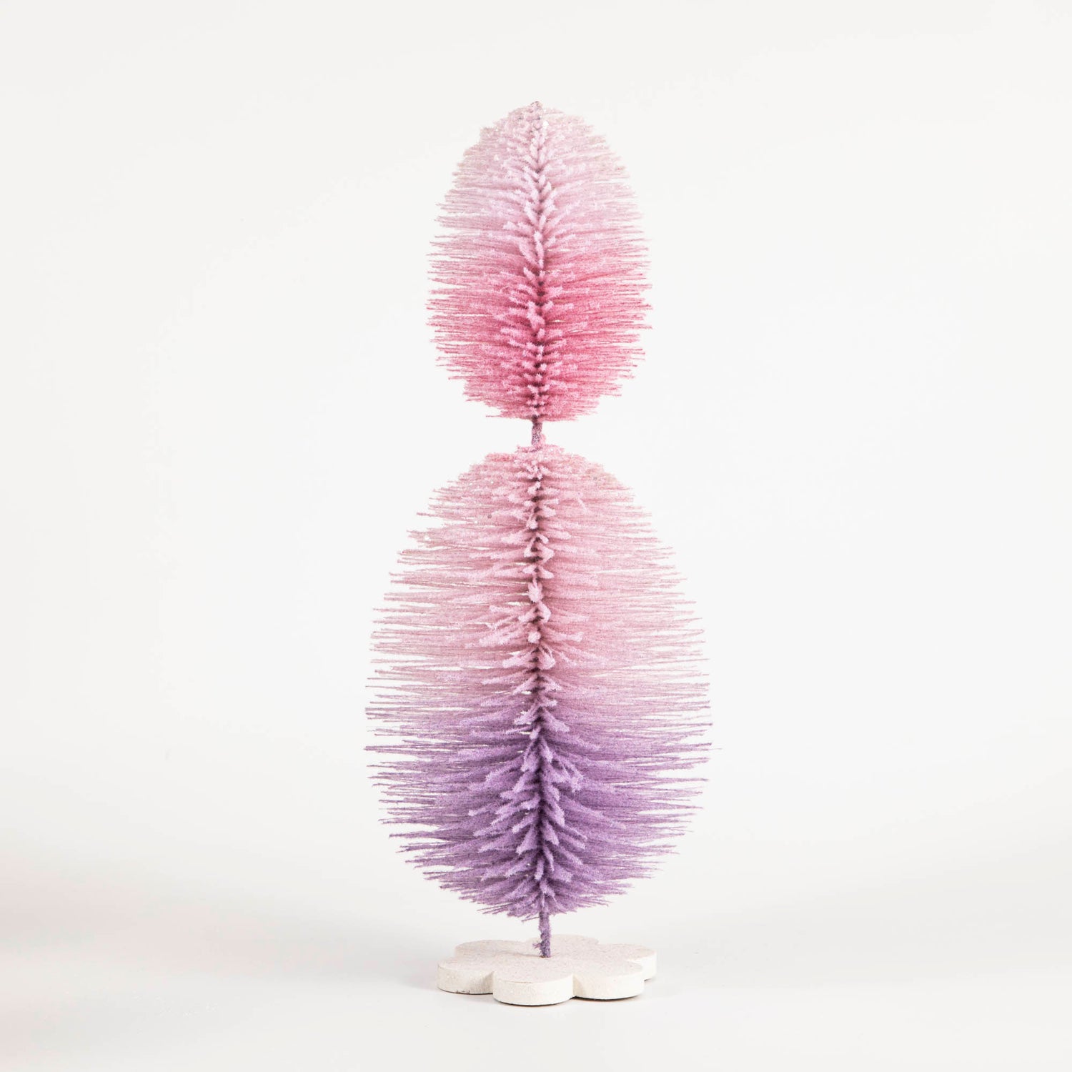 An exquisite Glitterville Sisal Topiary Tree, adorned in vibrant pink and purple hues, gracefully stands against a pristine white background.