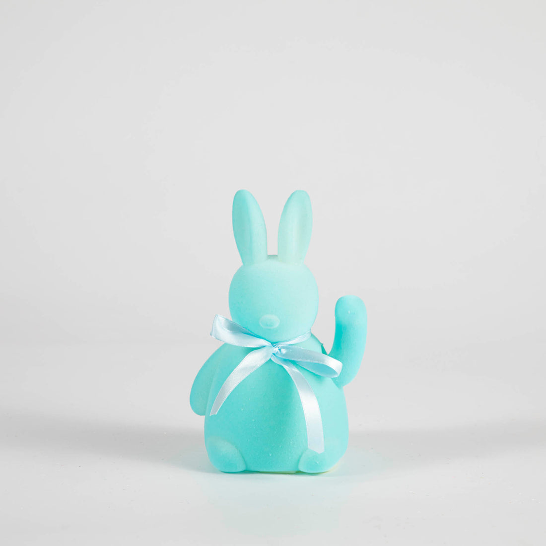 A Waving Flocked Bunny with a bow on a white background from Glitterville.