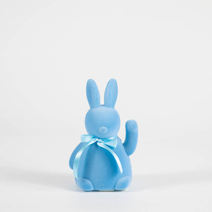 A Waving Flocked Bunny cottontail figurine with a blue bow by Glitterville.