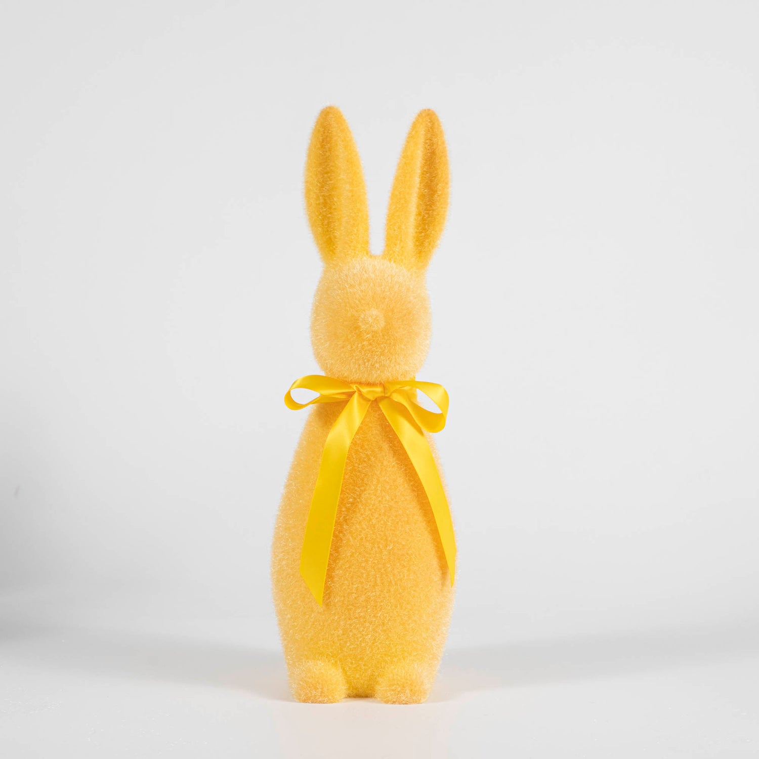 A yellow Medium Flocked Pastel Button Nose Bunny with a yellow bow on a white background, perfect for Easter decorations by Glitterville.