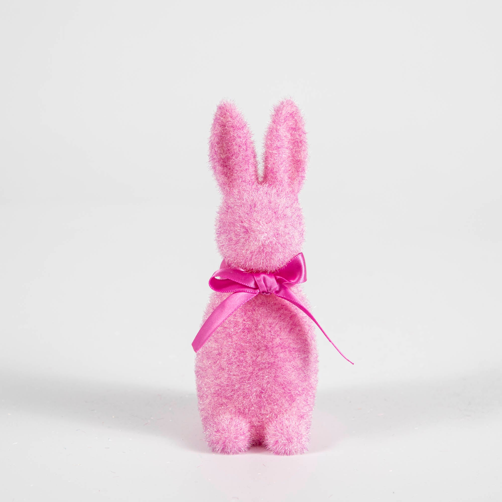 A Small Flocked Pastel Button Nose Bunny with a pink bow, perfect for holiday Easter egg hunts. (Product Name: Small Flocked Pastel Button Nose Bunny; Brand Name: Glitterville)