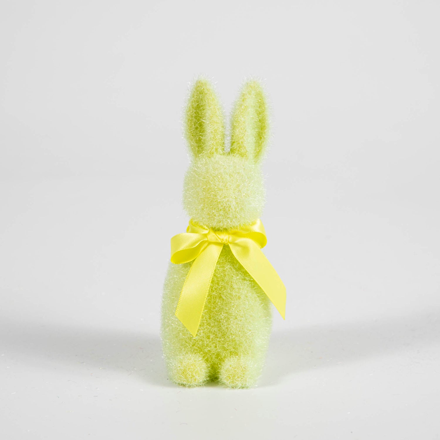 A Small Flocked Pastel Button Nose Bunny with a lime green bow on a white background.