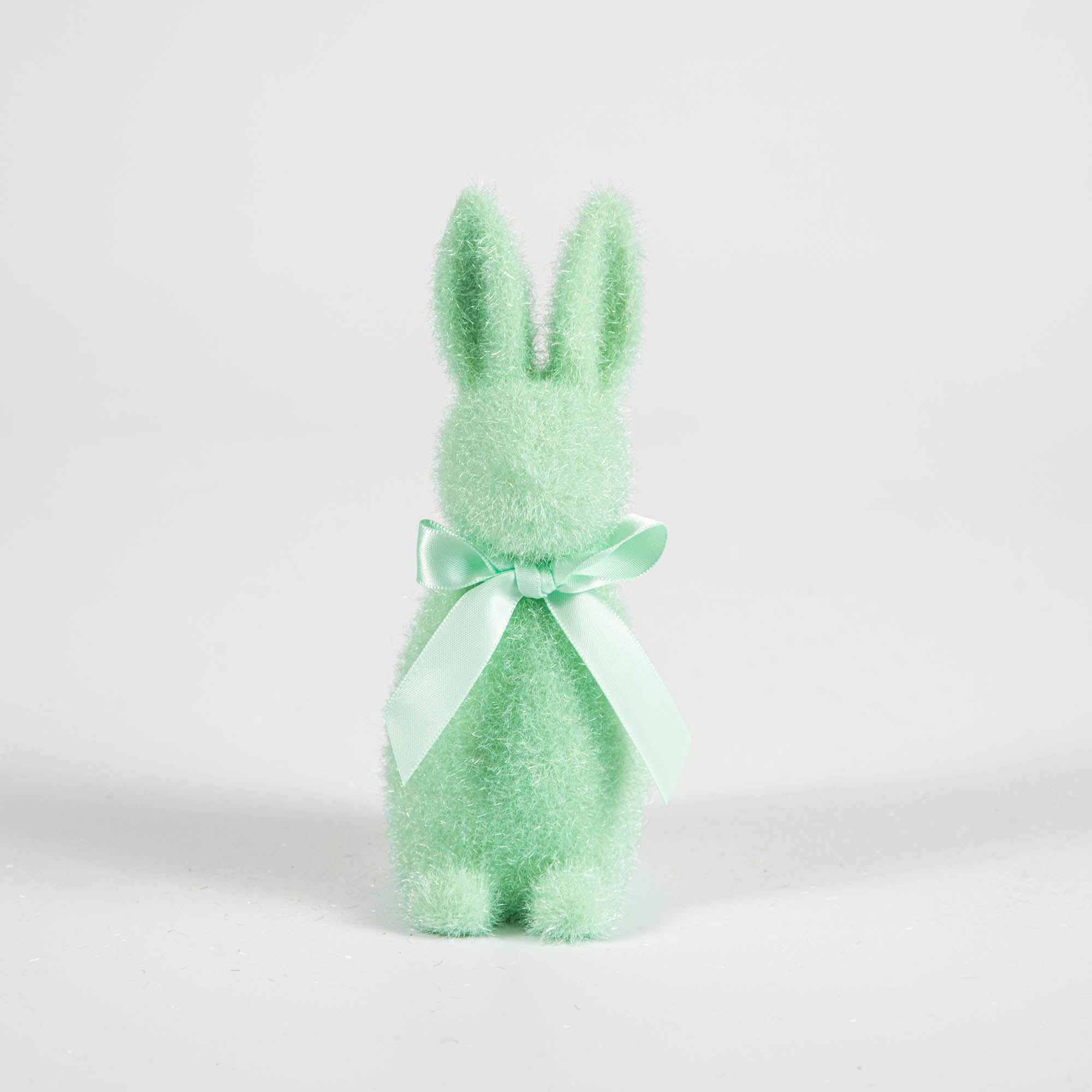 A Small Flocked Pastel Button Nose Bunny with a bow around it&