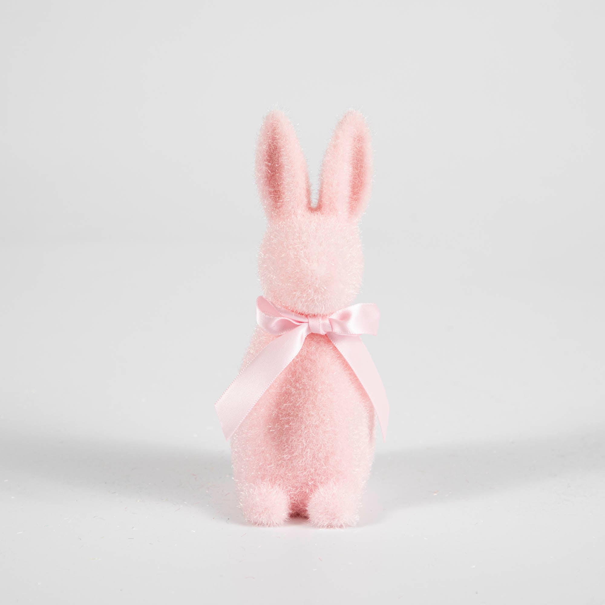 A Small Flocked Pastel Button Nose Bunny with a pink bow on a white background, made by Glitterville.