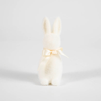 A Small Flocked Pastel Button Nose Bunny with a bow around its neck.