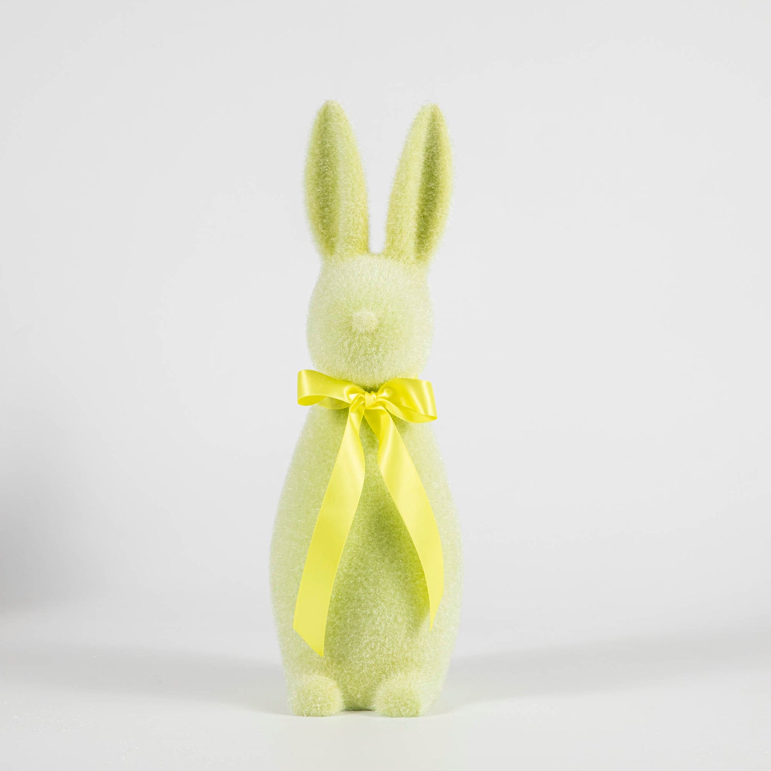 A Glitterville Medium Flocked Pastel Button Nose Bunny with a yellow bow on a white background.