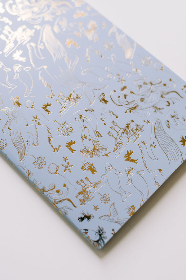 A blue Narwhal Notebook Duo with gold foil on it, perfect for those who love Good Juju Ink notebooks.