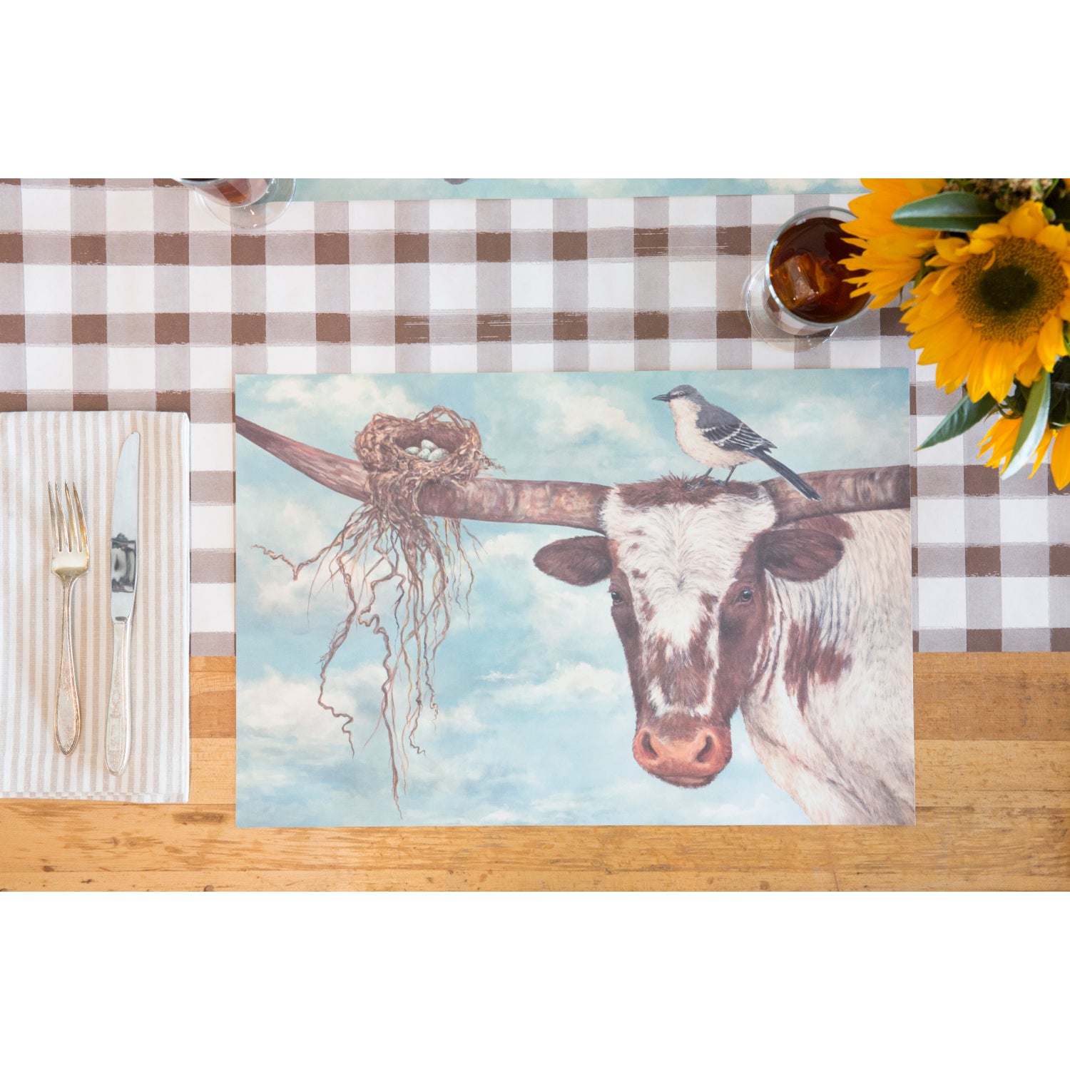 A place setting with Buford &amp; Agnes paper placemat on a Brown Painted Check Table Runner