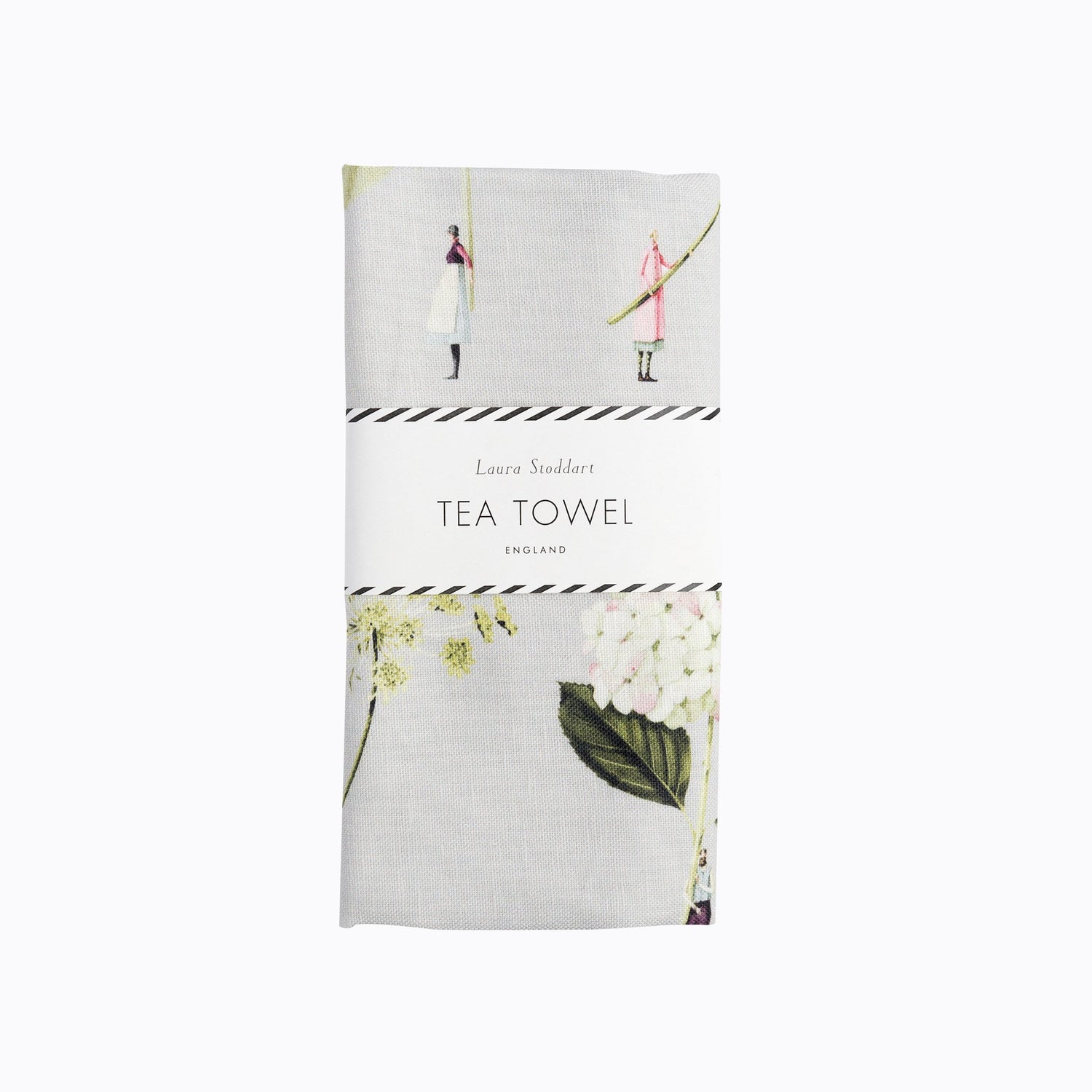 The Tea Towel in retail packaging, folded neatly with a white paper belly band that reads &quot;Laura Stoddart Tea Towel, England&quot;. 