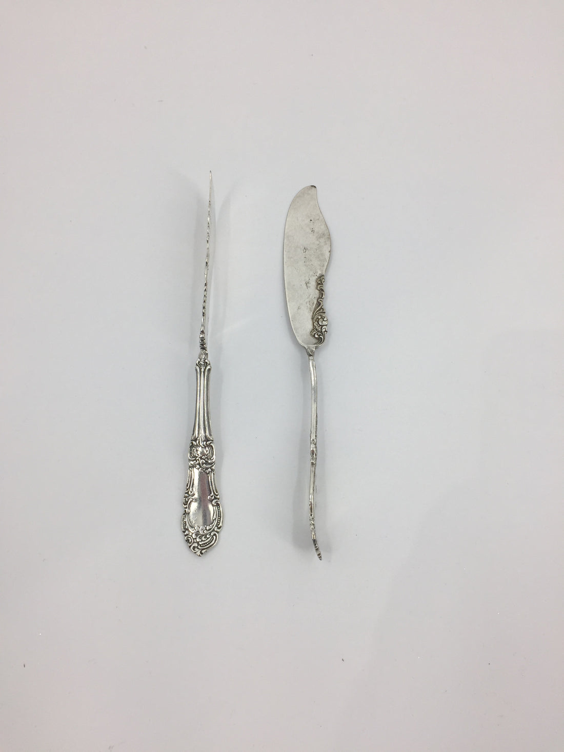 Two Hester &amp; Cook Twisted Butter Knives Open Stock on a white surface.