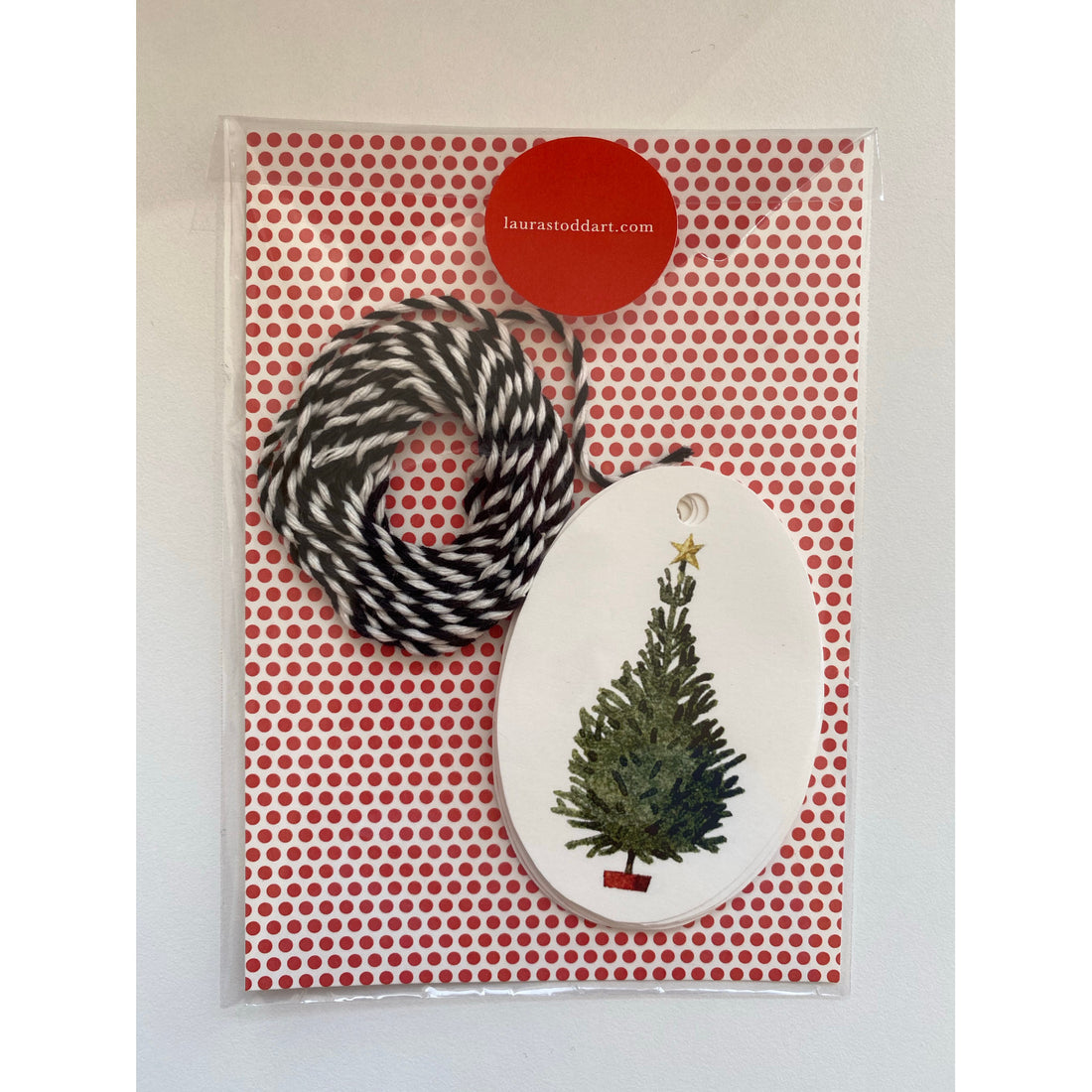 An environmentally responsible Christmas Trees Gift Tags ornament in a red and white gift bag, perfect for Christmas presents or as Hester &amp; Cook gift tags.