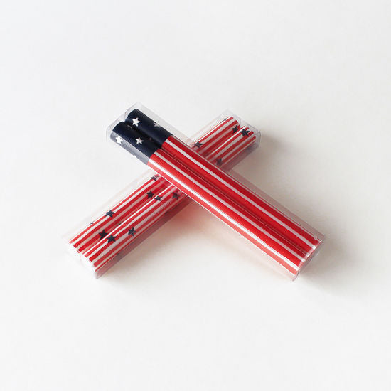 Two Star Spangled Taper Candles by Glitterville arranged in a cross shape, wrapped with a Stars &amp; Stripes-themed design.