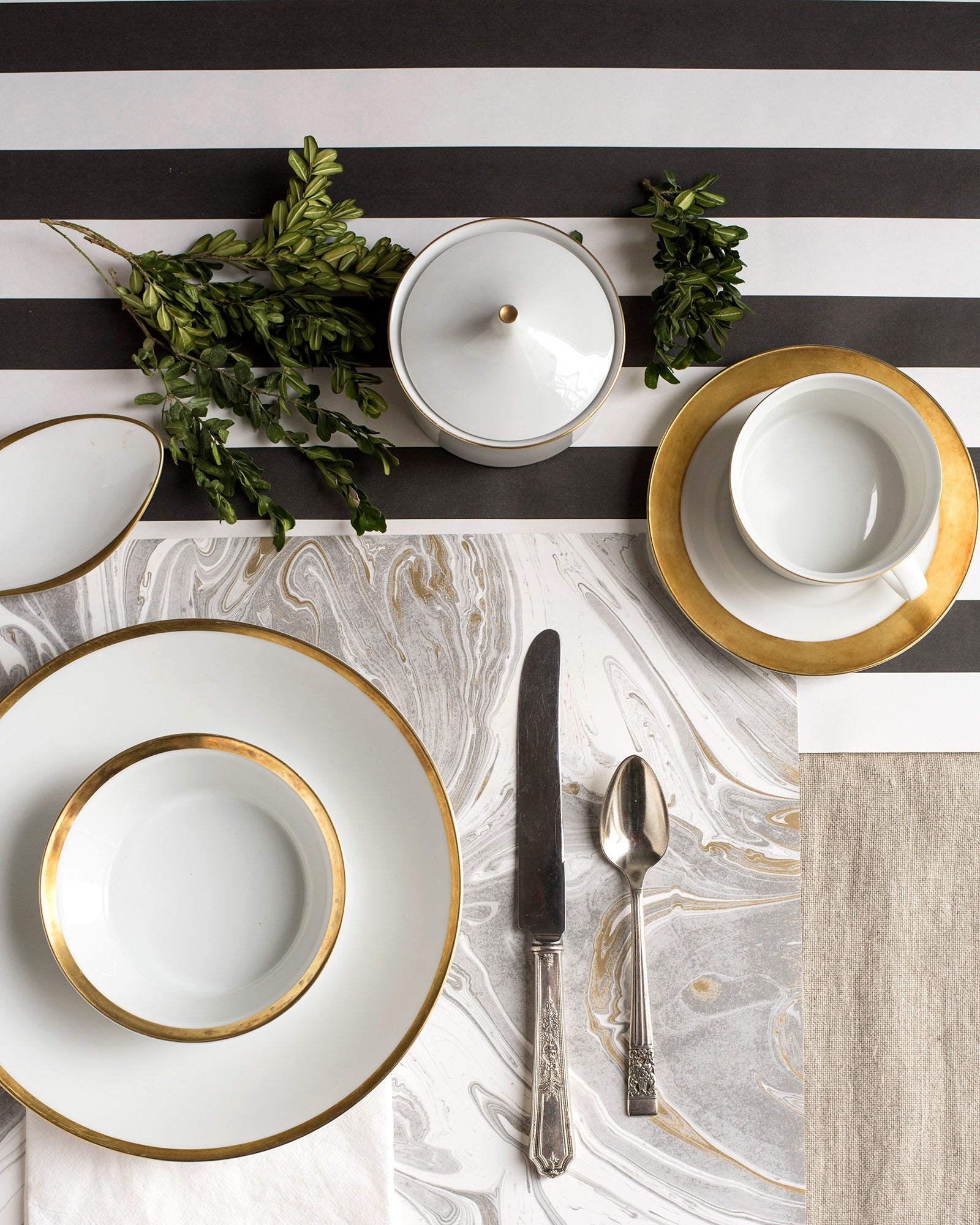 The Black Classic Stripe Runner under an elegant gold-accented place setting, from above.