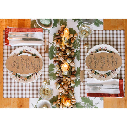 Overview of 2 place settings with Hester &amp; Cooks Brown Painted Check Paper Placemats with plates and silverware and Kraft Table Accent featuring the menu