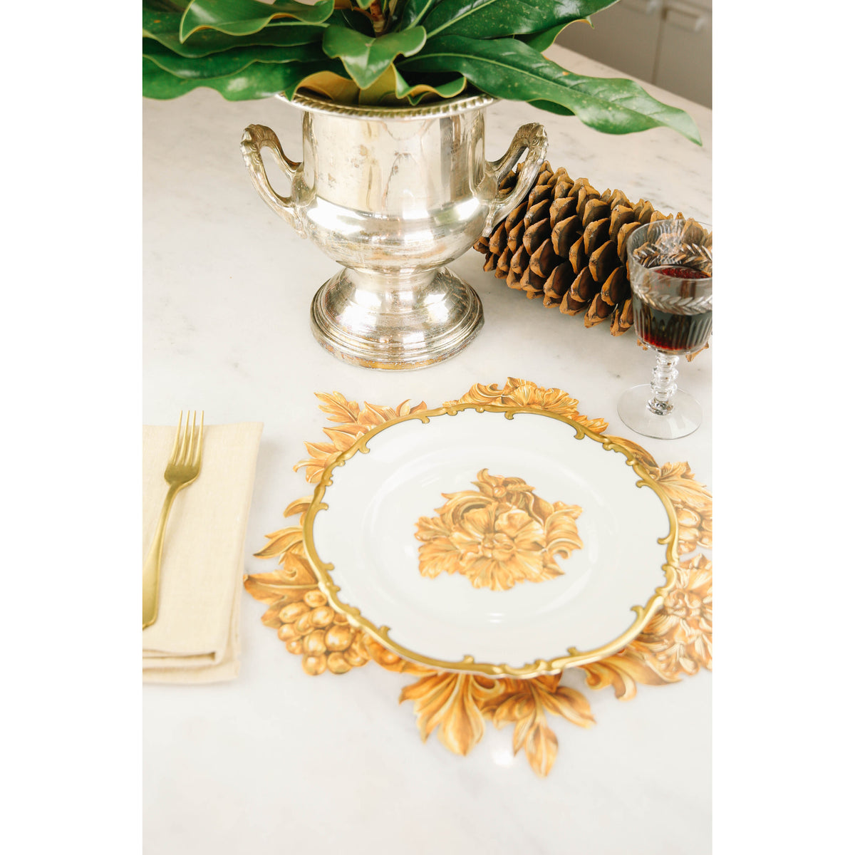 An elegant place setting featuring Gold Flora Serving Confetti under and on the plate.