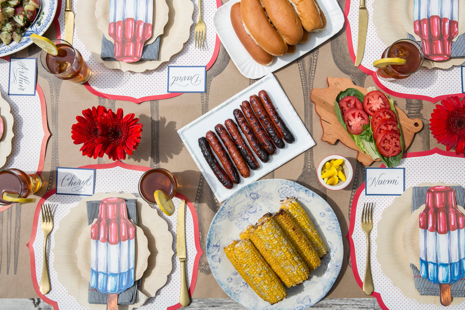 USA-themed 4th of July table setting with hot dogs and corn on the cob, featuring a festive tablescape adorned with Hester &amp; Cook&