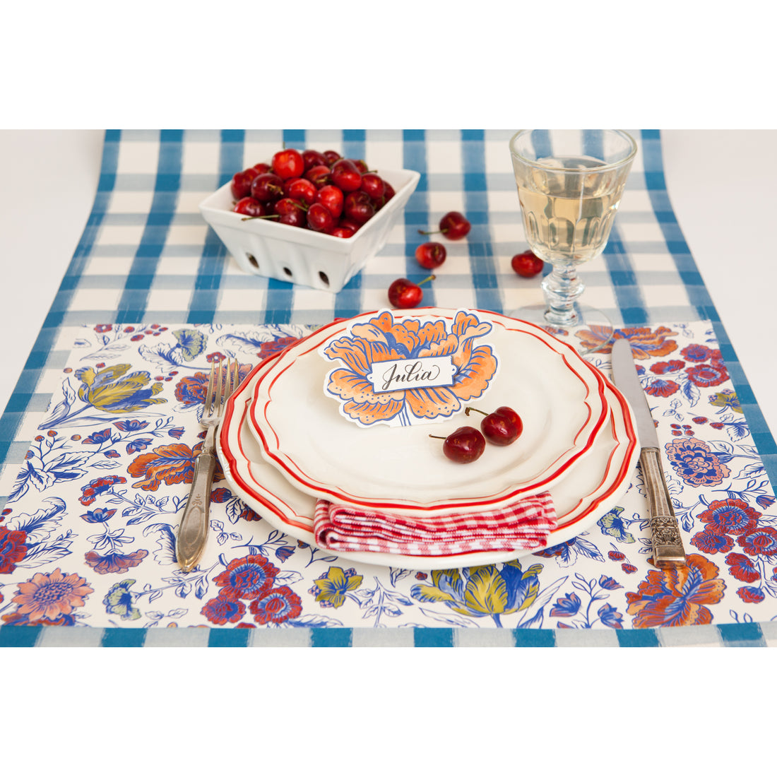 An elegant floral place setting featuring a Jardiniere Place Card labeled &quot;Julia&quot; standing on the plate.