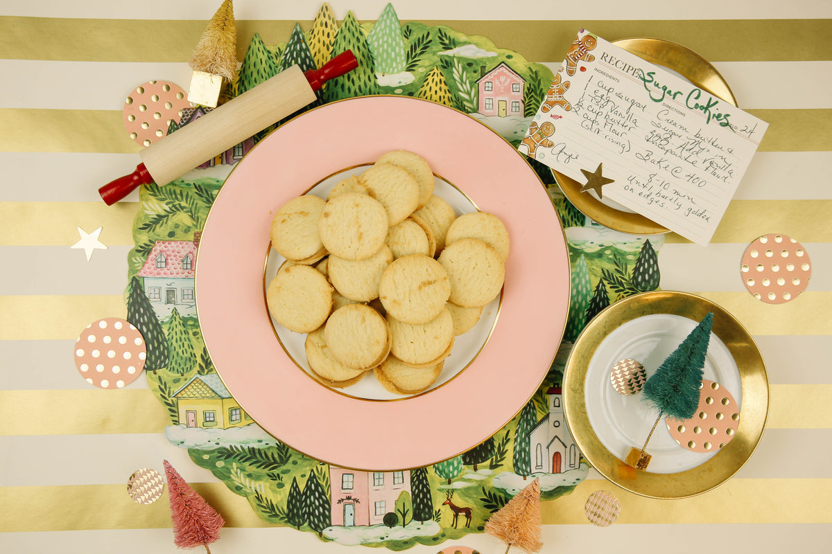 A plate of cookies on a table next to a Christmas tree with gift wrapping, featuring the Gold Classic Stripe Runner by Hester &amp; Cook.