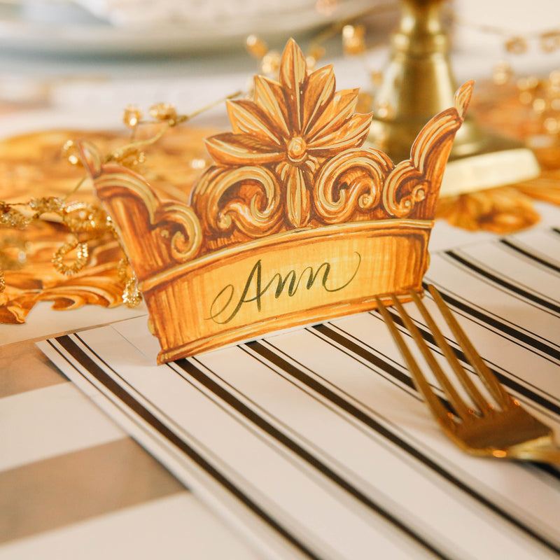 Close-up of a Crown Place Card labeled &quot;Ann&quot; on an elegant place setting.