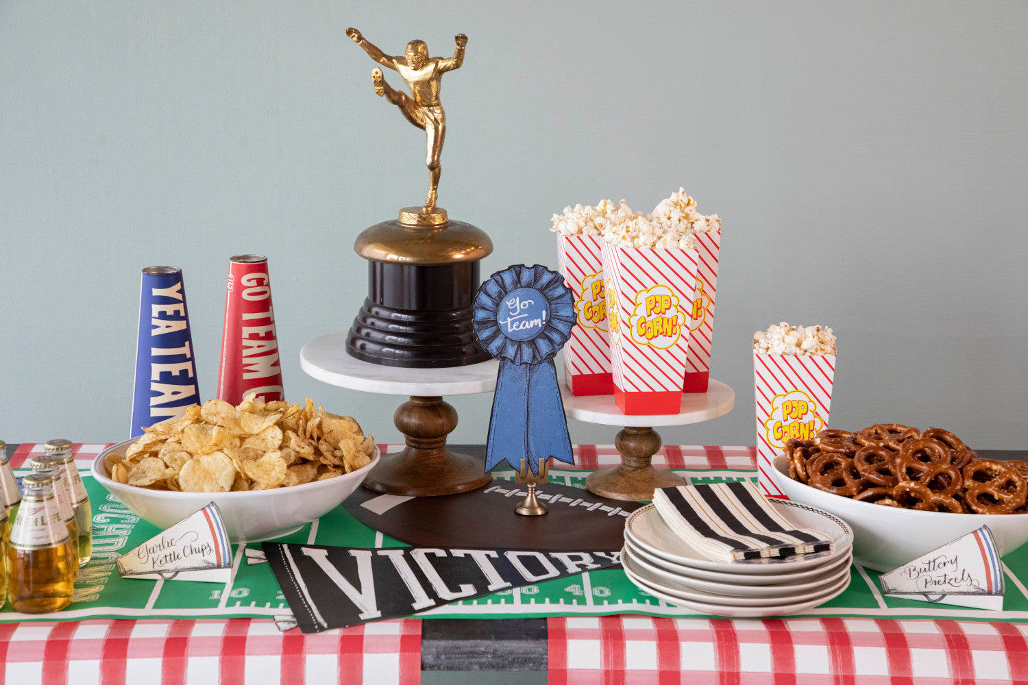 A table with a set of 12 Hester &amp; Cook Die-cut Pennant Placemat team spirit snacks.