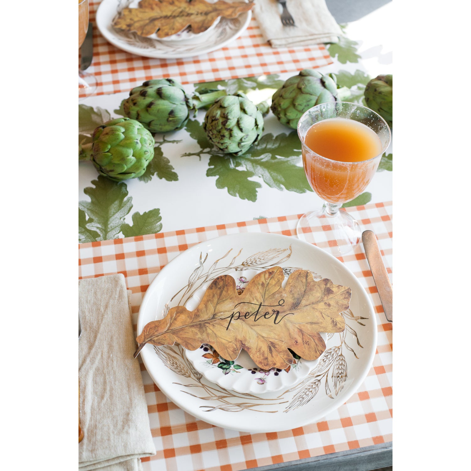 The Orange Painted Check Placemat under an elegant fall-themed table setting.