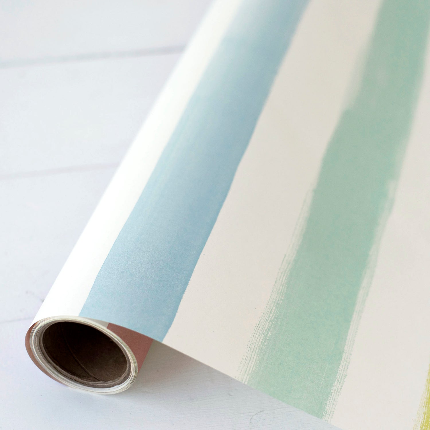 Close-up of the Sorbet Painted Stripe Runner partially unrolled on the cardboard tube.