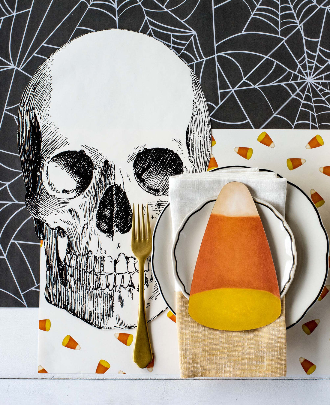 The Die-cut Skull Placemat under a spooky Halloween-themed place setting, from above.