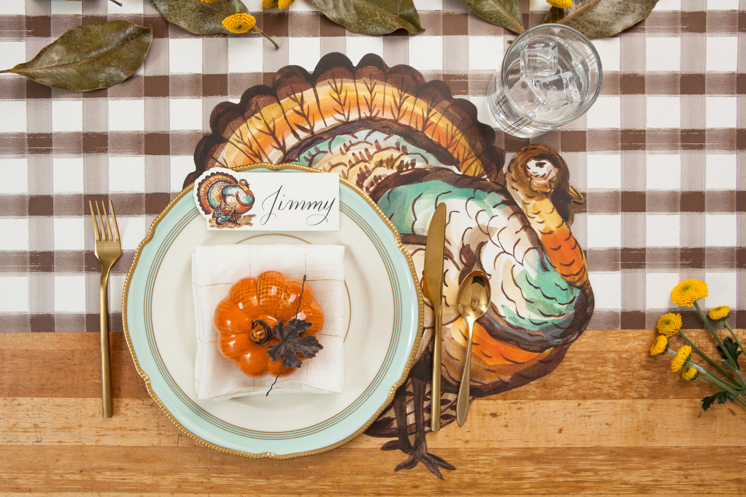 Top-down view of an elegant Thanksgiving place setting featuring a Thanksgiving Turkey Place Card labeled &quot;Jimmy&quot; resting on the plate.