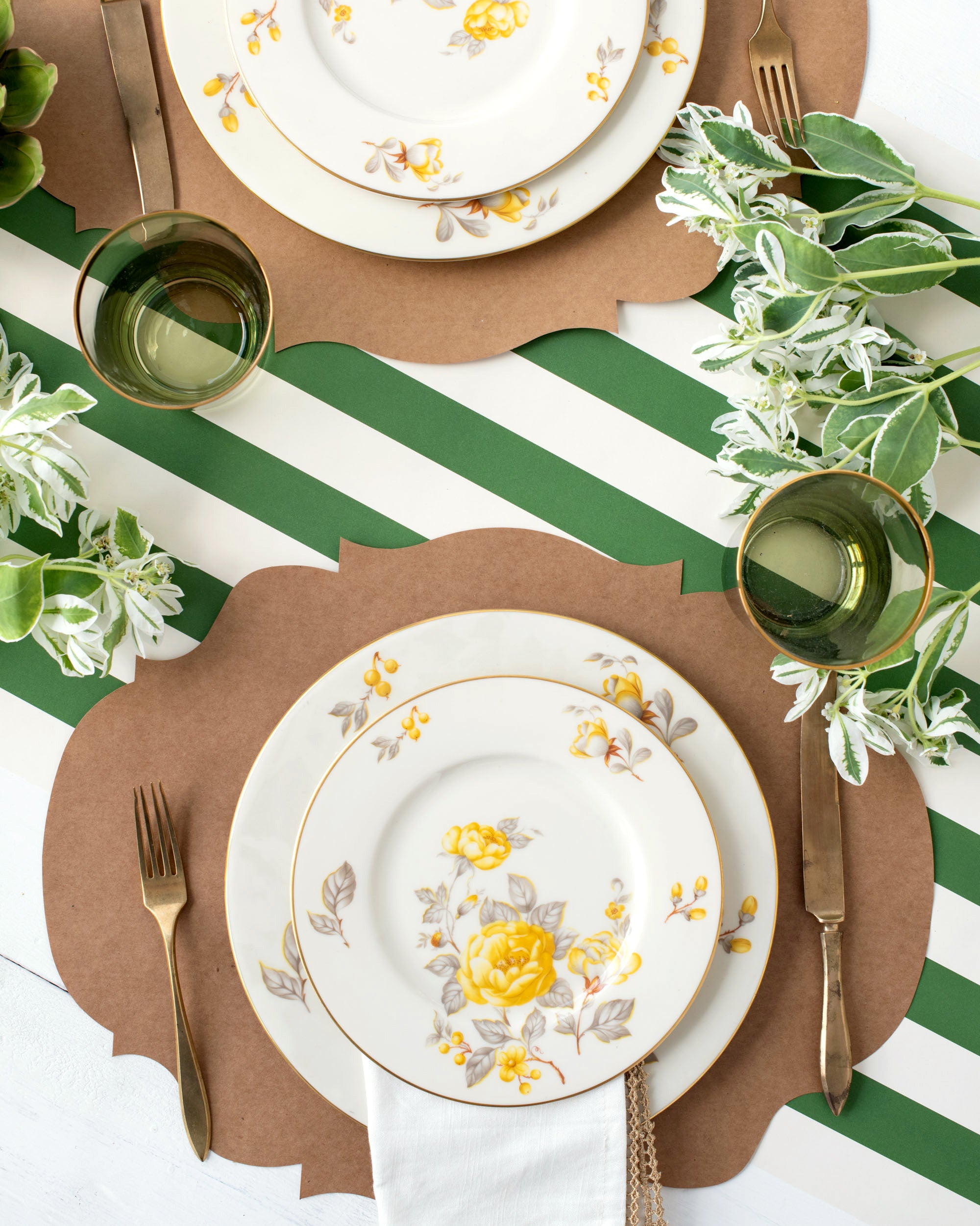 A table setting with plates, silverware, and flowers on a Dark Green Classic Stripe Runner by Hester &amp; Cook.