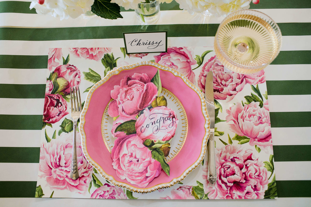 An elegant pink and green tablescape adorned with flowers, featuring Peonies In Bloom Placemats from Hester &amp; Cook for an added touch of sophistication.