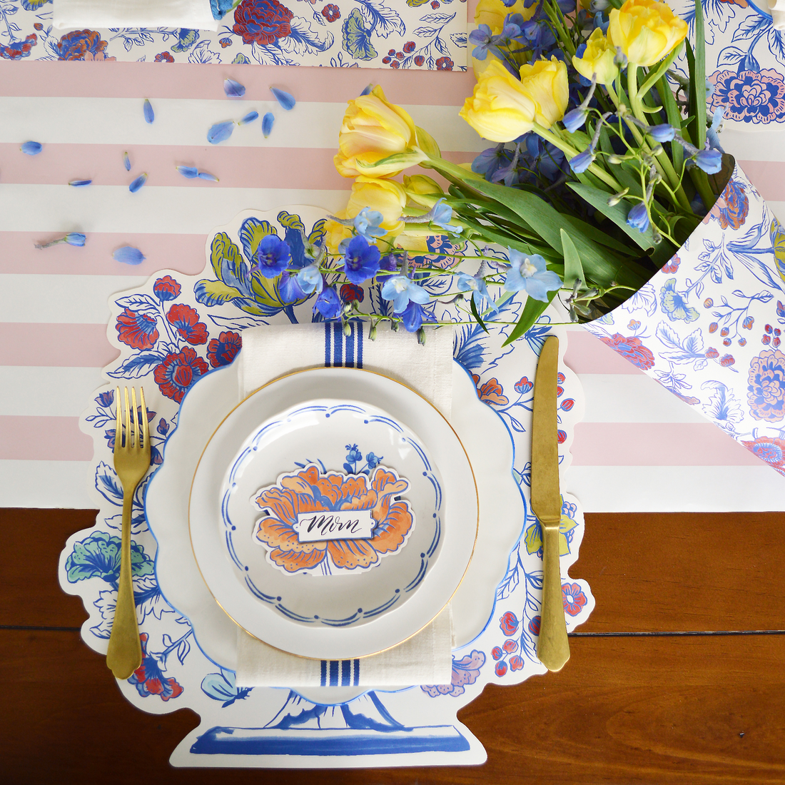 A die-cut Jardiniere Placemat with flowers in a china blue vase from the Hester &amp; Cook Collection.