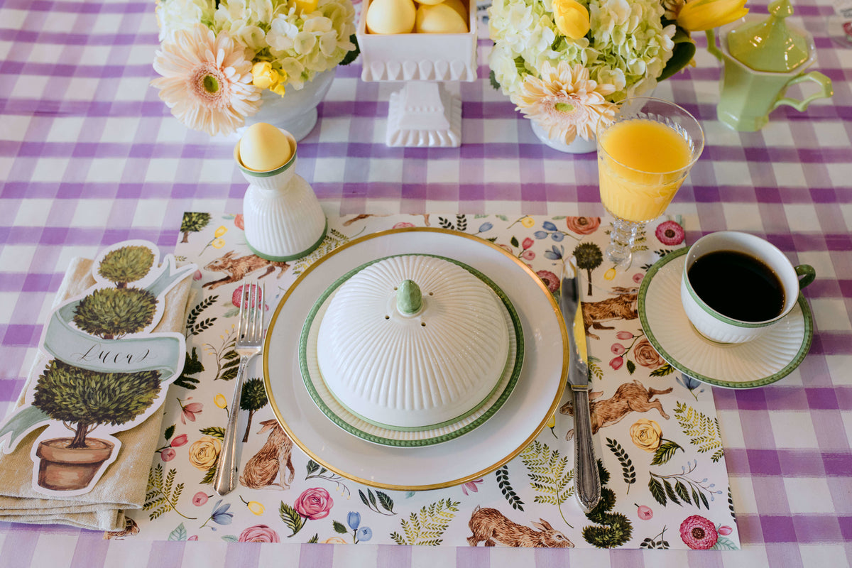 The Bunny Garden Placemat under an elegant Easter place setting on the Lilac Painted Check Runner.