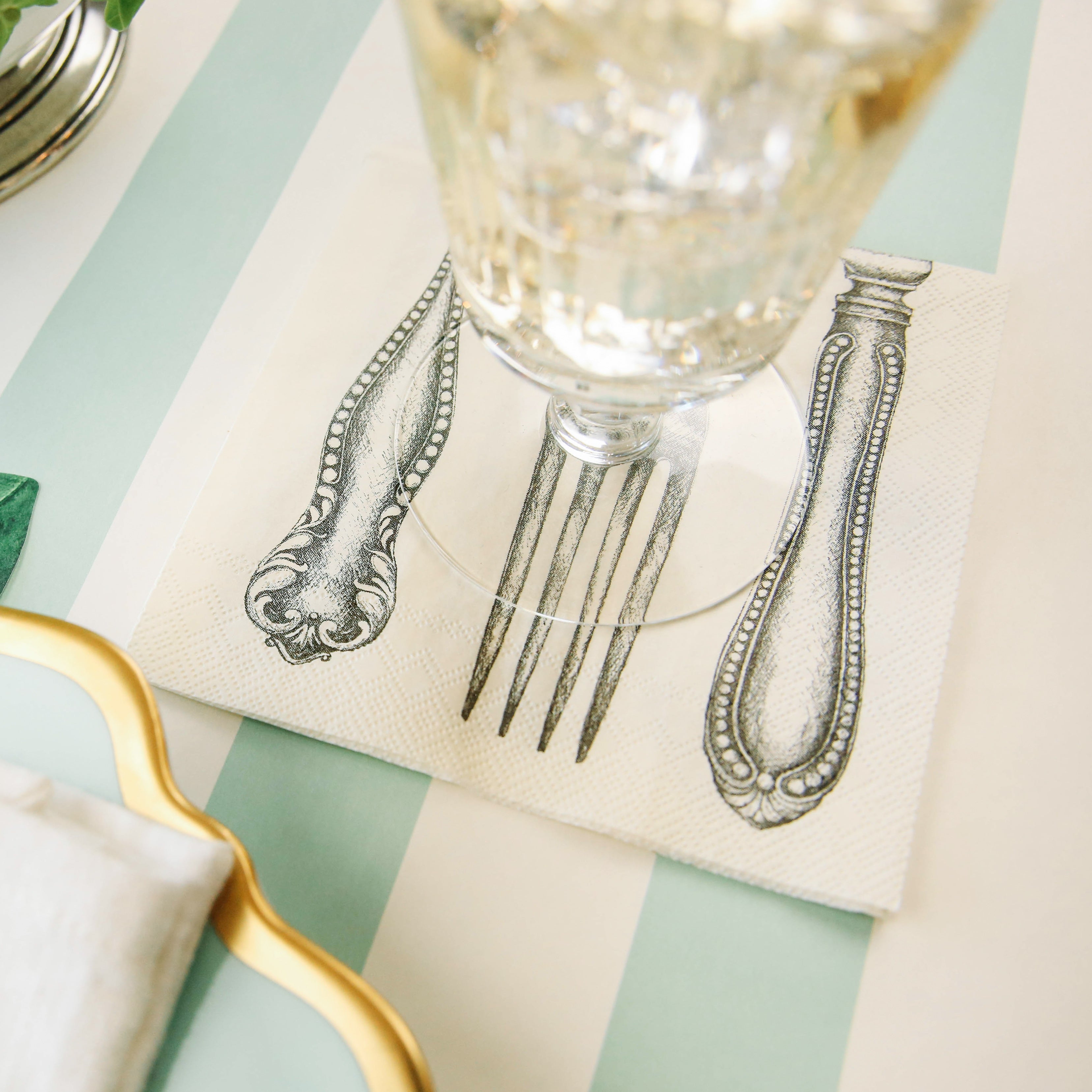 A Classic Cutlery Napkin by Hester &amp; Cook with a fork and knife on it, perfect for a party table setting.