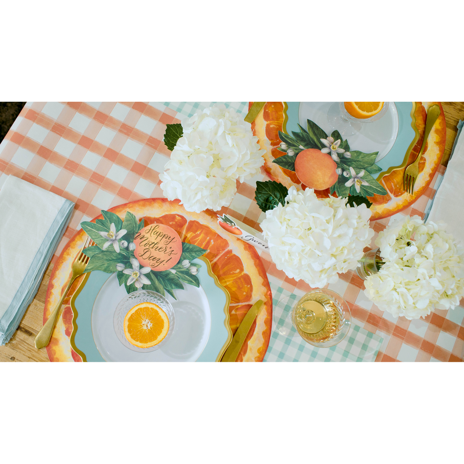 The Orange Painted Check Runner under a vibrant citrus-themed table setting, from above.