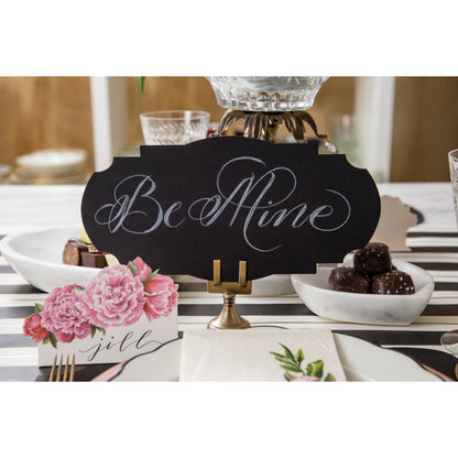 A black and white table setting with stylish Hester &amp; Cook Brass Place Card Holders and table accents, featuring a sign that says &quot;be mine.
