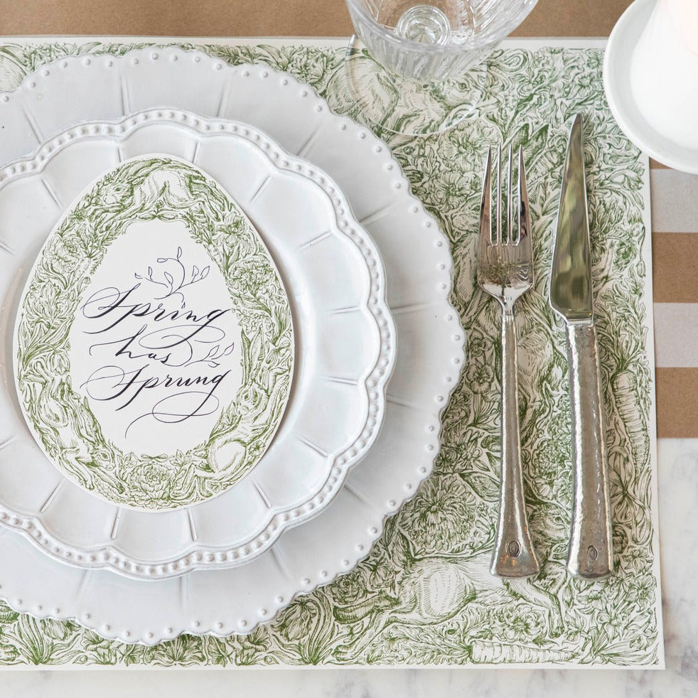 A table setting with oversized florals, including a Hester &amp; Cook Hare Promenade Placemat, fork and knife.