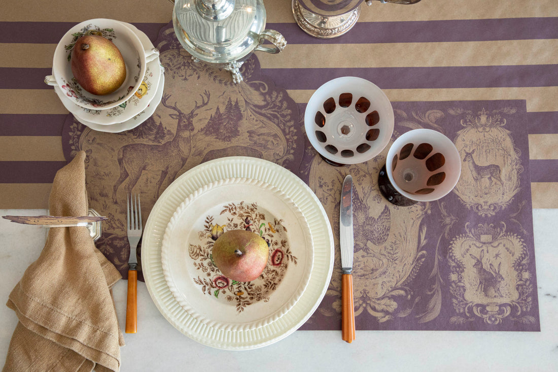 The Fable Toile Placemats, classic and die-cut, under a place setting, from above. 