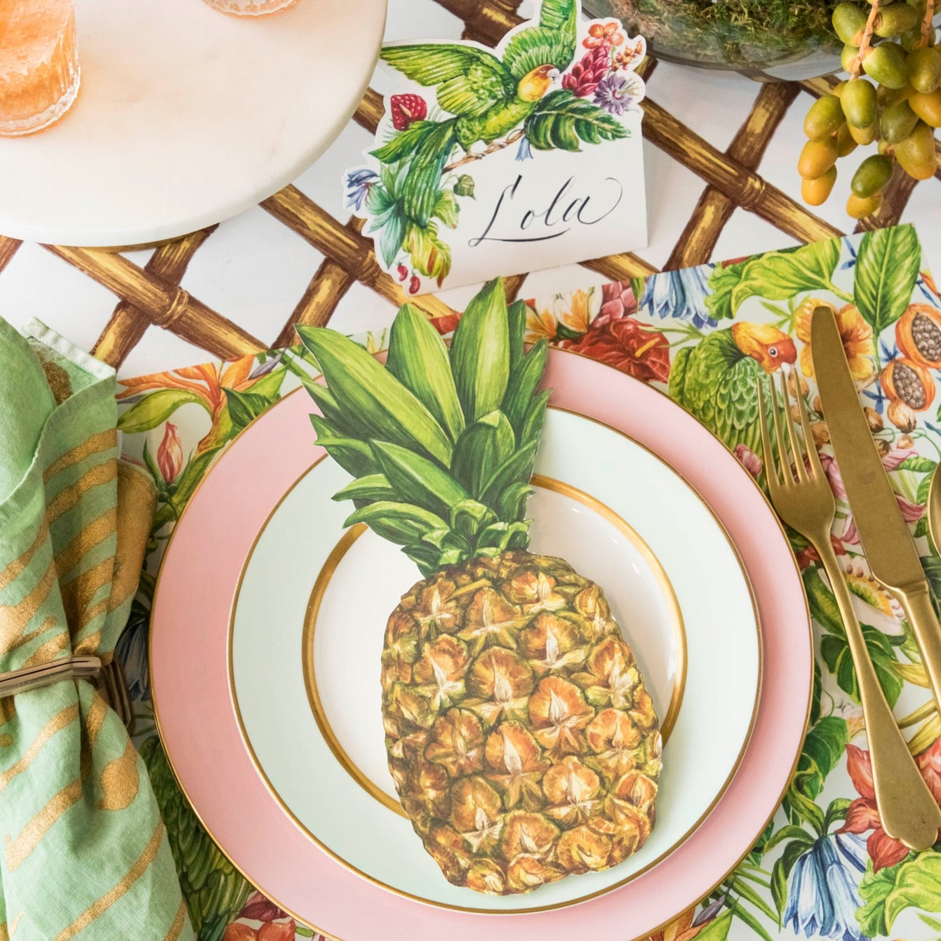 A tropical table setting with a pineapple table accent on a Birds of Paradise Placemat by Hester &amp; Cook.