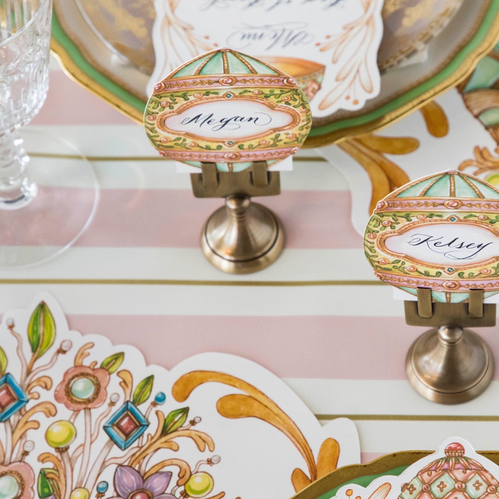 A table setting with the Pink &amp; Gold Awning Stripe Runner by Hester &amp; Cook, pink and gold plates, napkins, and place cards.
