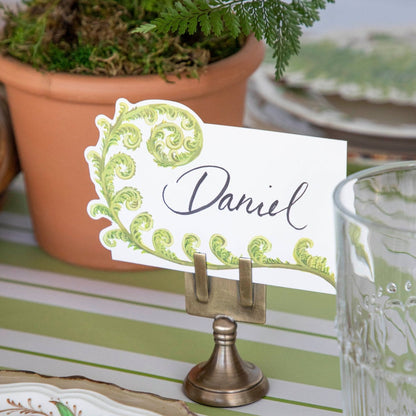 A table setting with place cards and a potted plant featuring a Hester &amp; Cook Fiddlehead Fern Place Card.